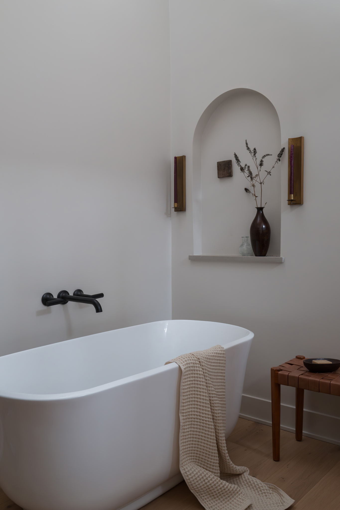 Bathroom niche detail with bronze vase and matte black fixtures