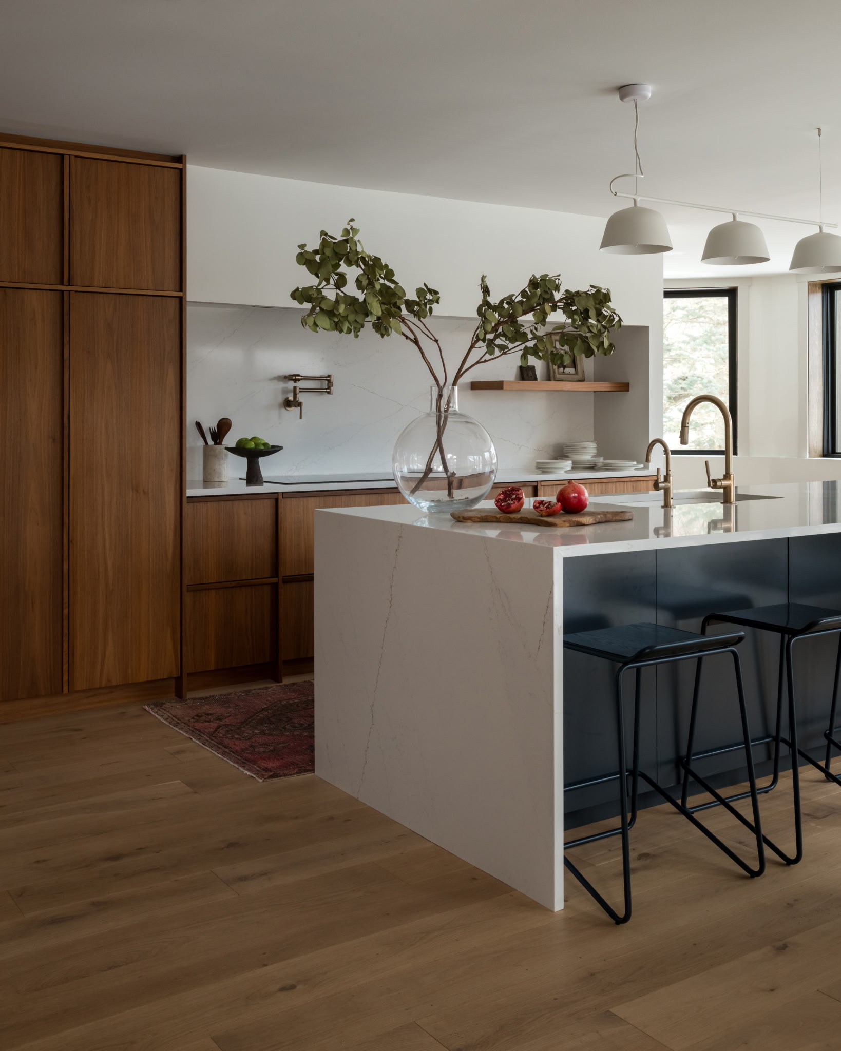 Eucalyptus branch over marble backsplash with fruit bowl